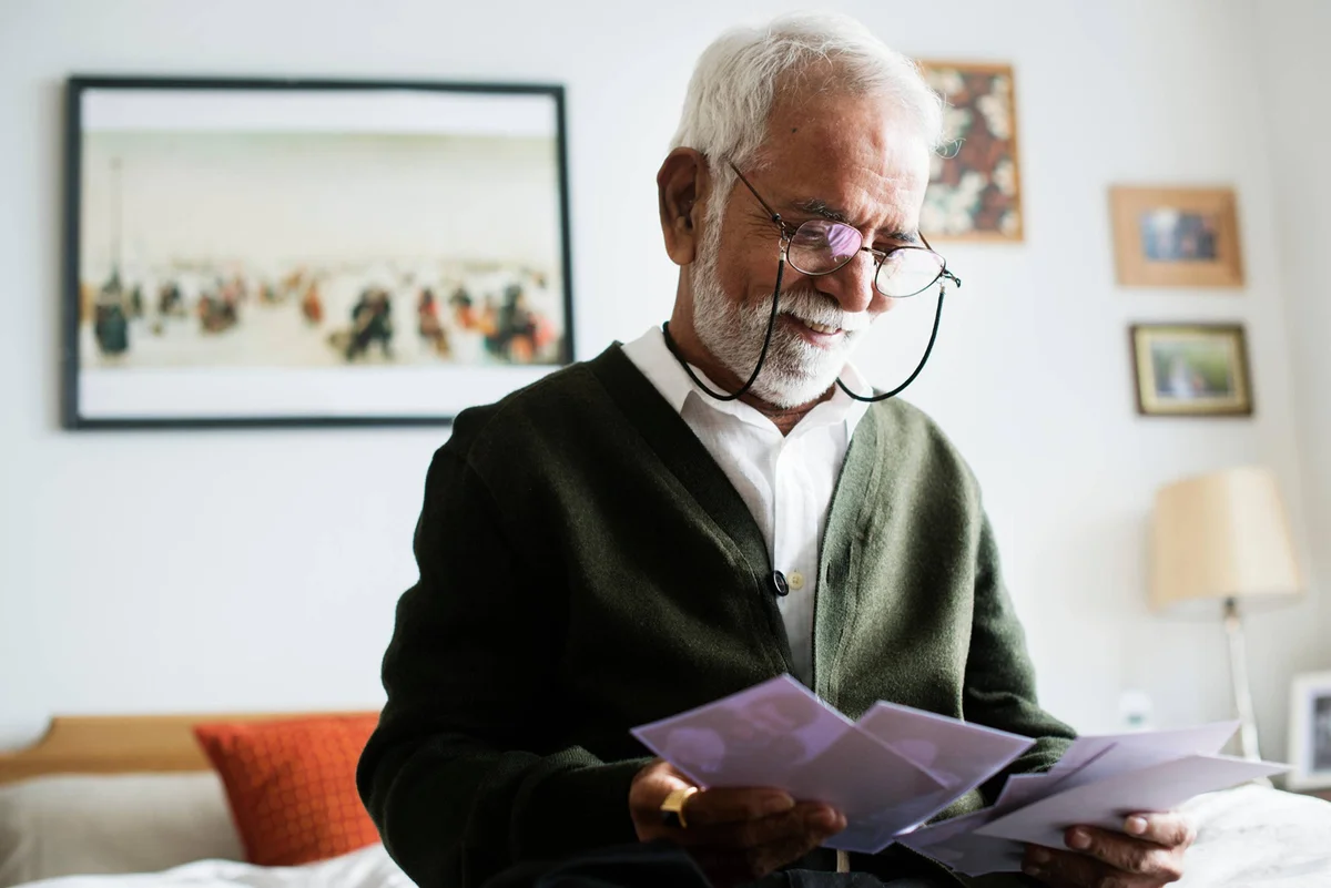 Older Gentleman looking at photos - domiciliary-care