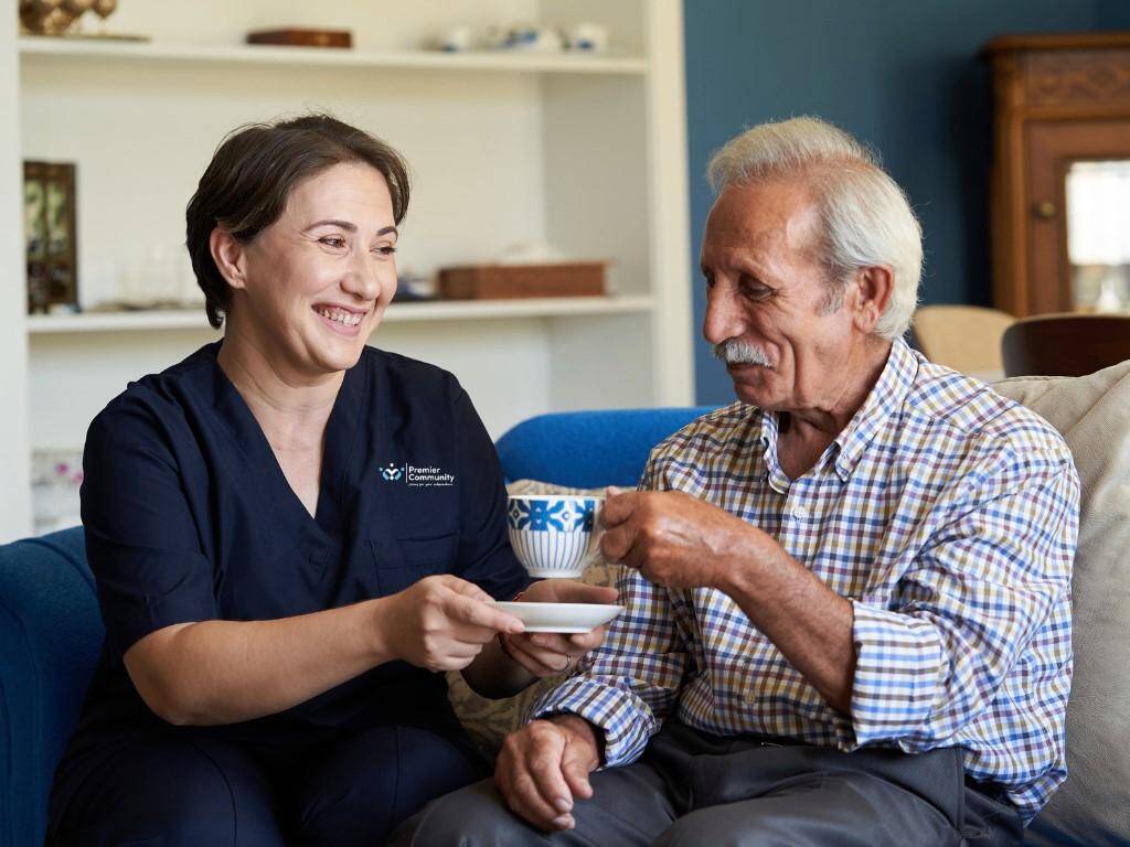 Inspiring Careers in Care: A carer hands a service user a cup of tea