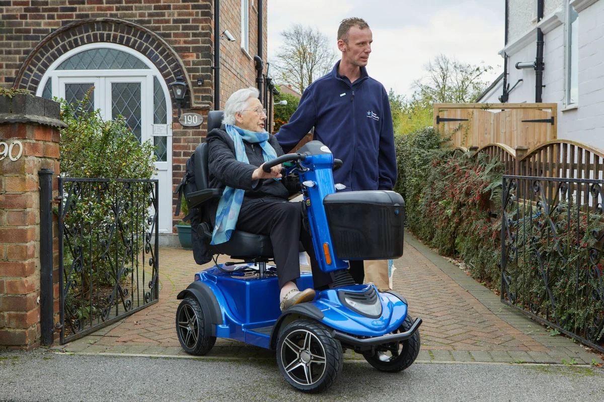 Essential Mobility Scooter Service Tips: Premier Community carer with a service user on a mobility scooter