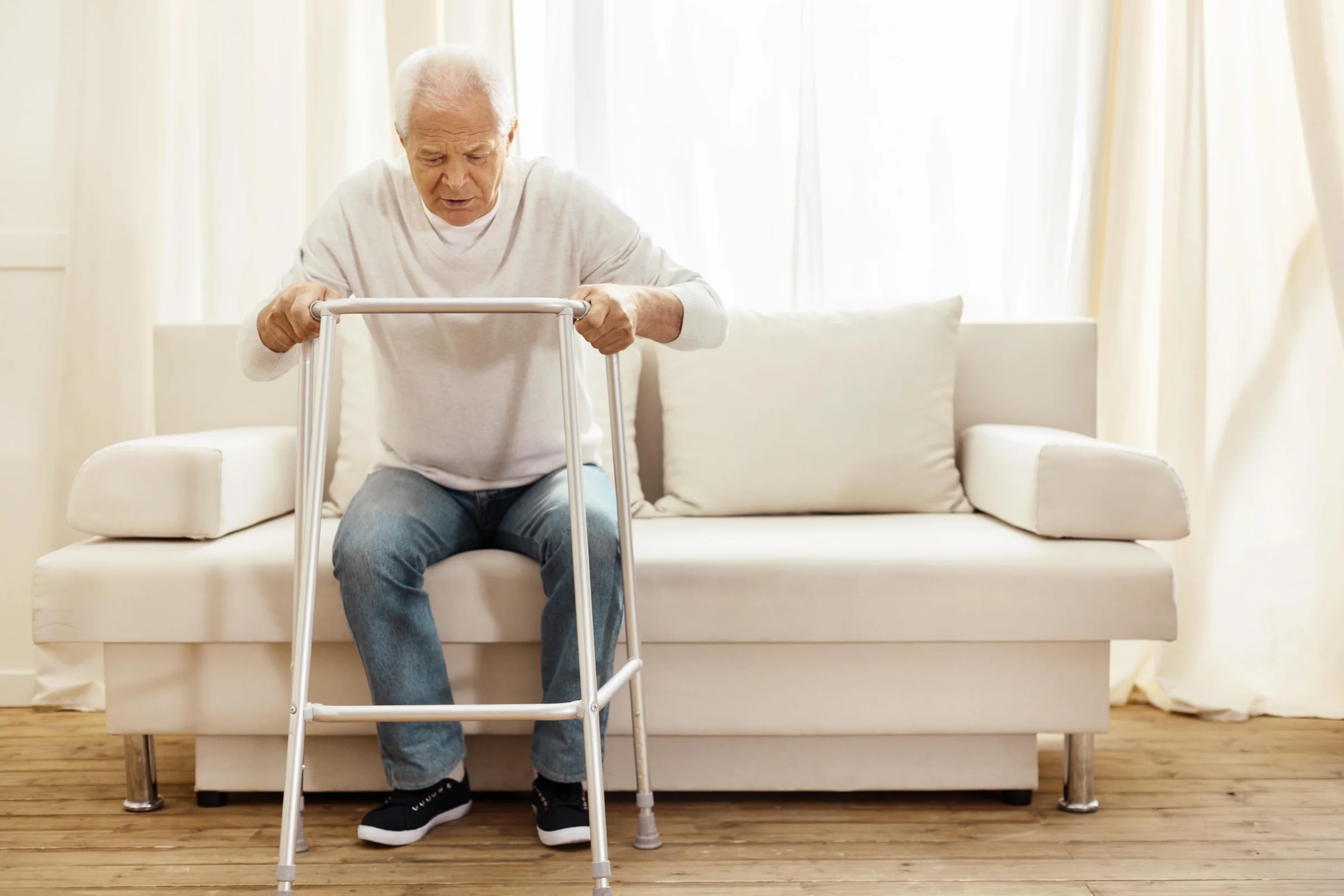 Older gentleman using a walking frame as a mobility aid