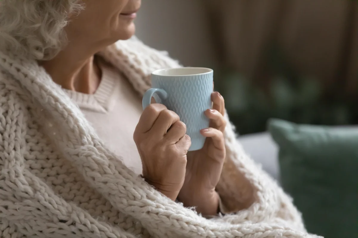 Older lady wrapping up warm in a blanket - Priority Services Register information