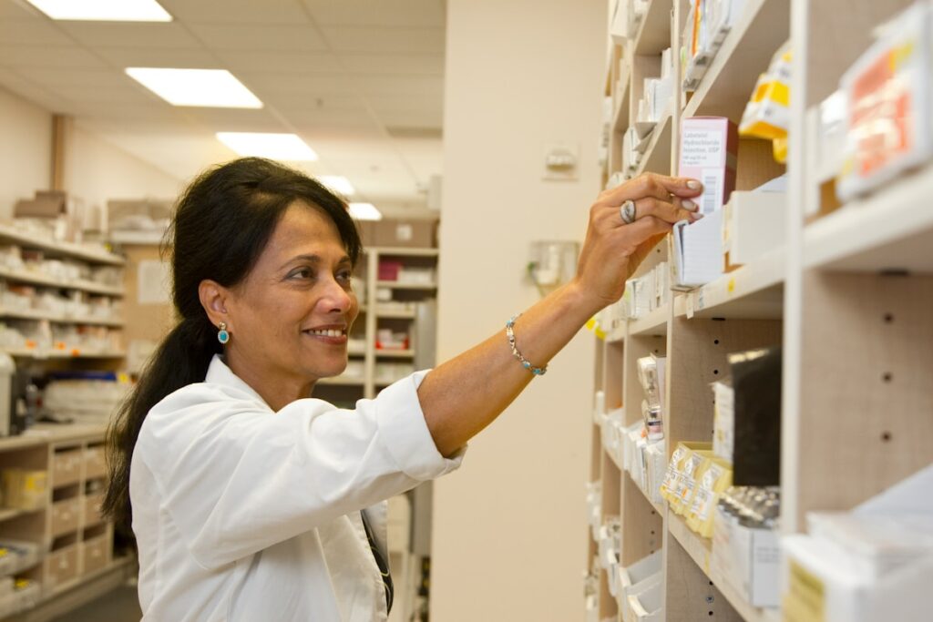 Pharmacist reaching for medication as part of the new Pharmacy First initiative