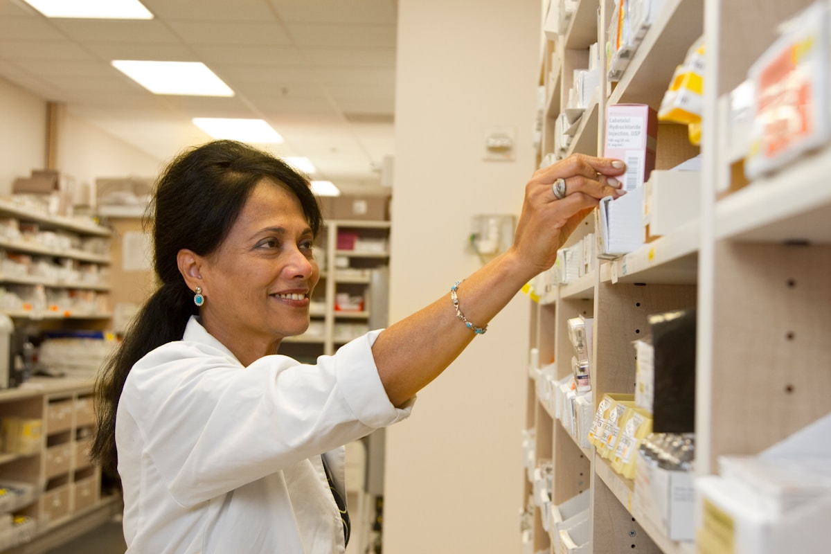 Pharmacist reaching for medication as part of the new Pharmacy First initiative