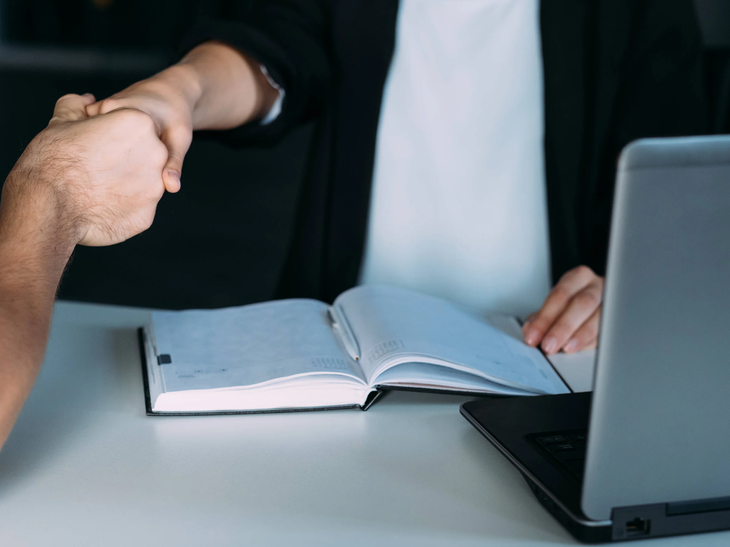 Image shows two people shaking hands demonstrating a professional commitment - Premier Community