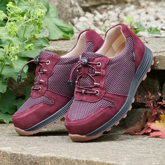 A pair of Cosyfeet Misty in Aubergine outdoors, standing upright between two steps.