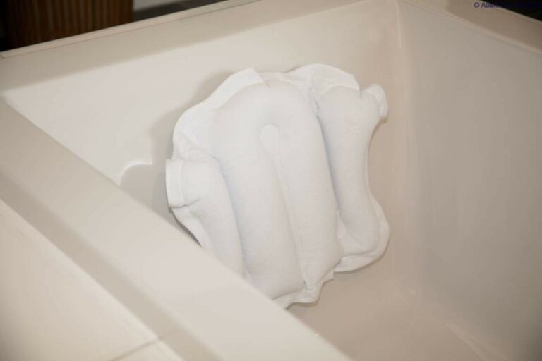 The Atlantis Bath Pillow on the side of a bath.