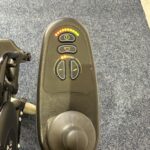 Quickie Rumba Powerchair Controls with a blue carpet behind.