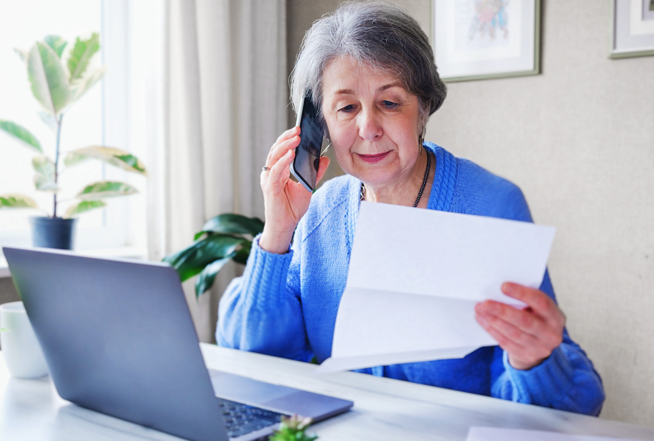An elderly woman pays her home care costs over the phone