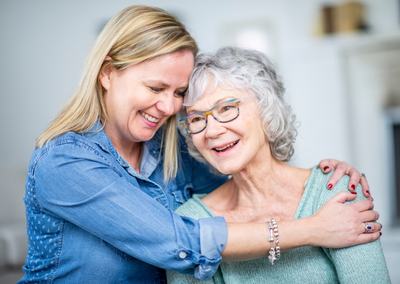 Woman giving an older lady a hug feeling relaxed thank to technology enabled care