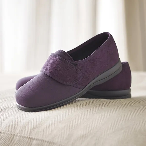 A pair of Cosyfeet Spicy Loganberry sitting on the end of the bed.