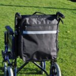 Splash Wheelchair Bag on a wheelchair on a grassy field.