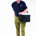 Wheelchair Underseat Bag being held by a person with the bag strap across the body.