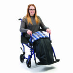 Drive Padded Leg Cosy on a Woman, sitting in a wheelchair, on a white background.