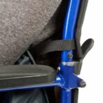 Drive Padded Leg Cosy Connector close up, showing it connected to the wheelchair, with a user sitting in it, on a white background.