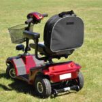 Splash Slipover Scooter Bag on a mobility scooter sitting on grass.