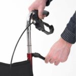Drive Tri-Walker with Seat Red Demonstration with two hands adjusting the handles.