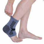 A persons legs with one ankle (right), closest to the camera wearing the Kedley Active Elasticated Ankle Supports on a white background.