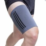 The Kedley Active Elasticated Thigh Support in grey on a mans thigh with his knee slightly lifted, giving the assumption of running, on a white background.