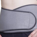 Kedley Pro-Light Neoprene Back Support around a models waist on a white background.