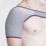 The Kedley Pro-Light Neoprene Shoulder Support on a topless male model's shoulder.