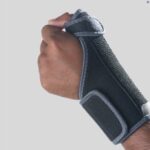 The Kedley Thumb Brace Support with Stays on a persons hand on a white background.
