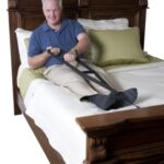 A senior man sitting in a bed pulling himself up with the Stander Bed Caddie.