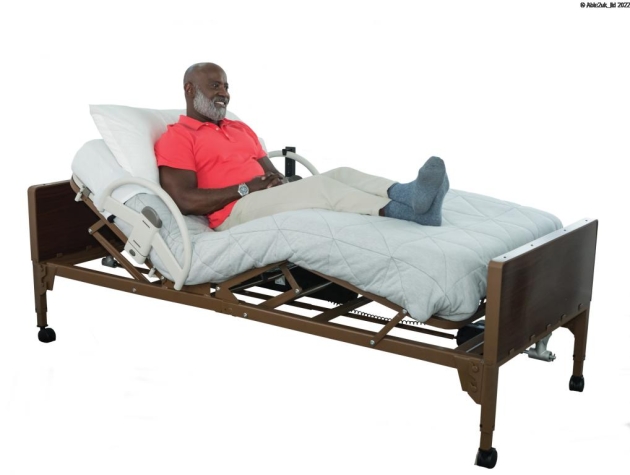 A senior man in a bed with the Stander EZ Click Bed Rail attached on the sides.