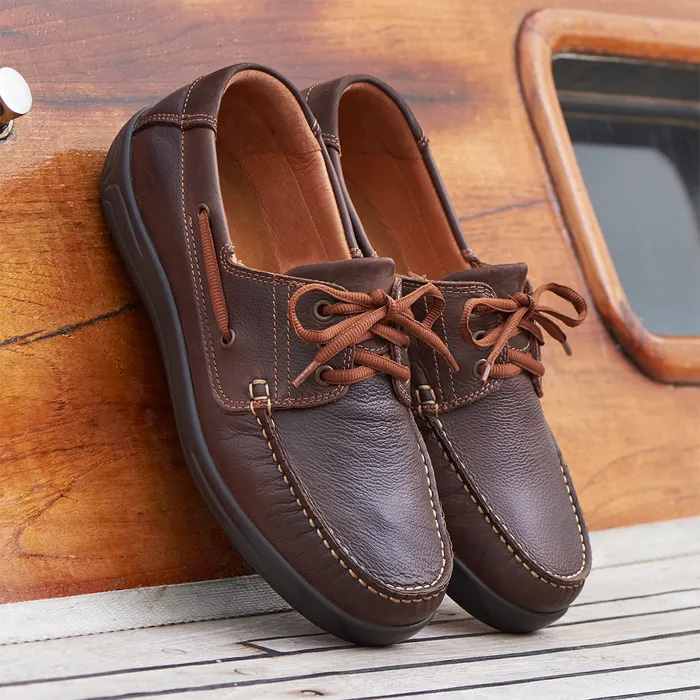 Cosyfeet Will Chestnut Brown sitting on the side of a classic boat.