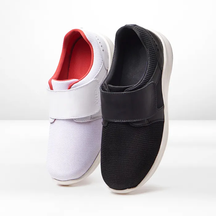 One each white and black Cosyfeet Victor trainer on a white background.