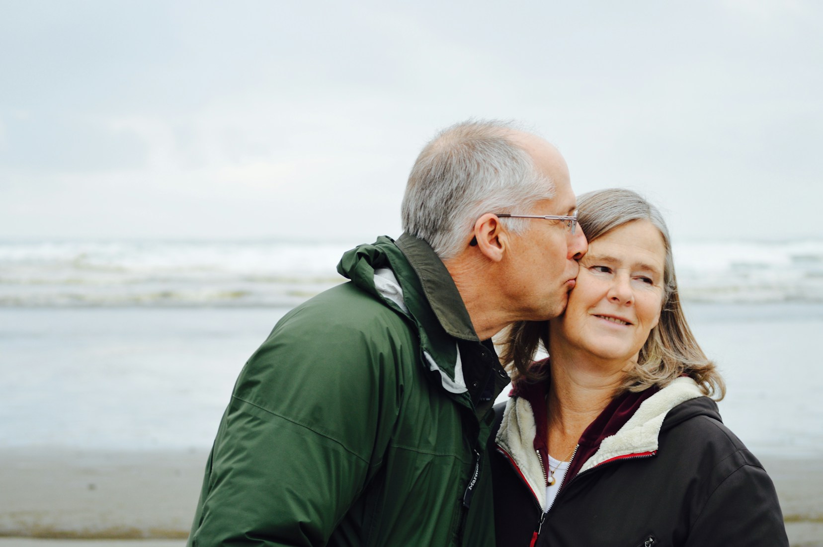 Older couple with man kissing a woman on the cheek representing our respite care services
