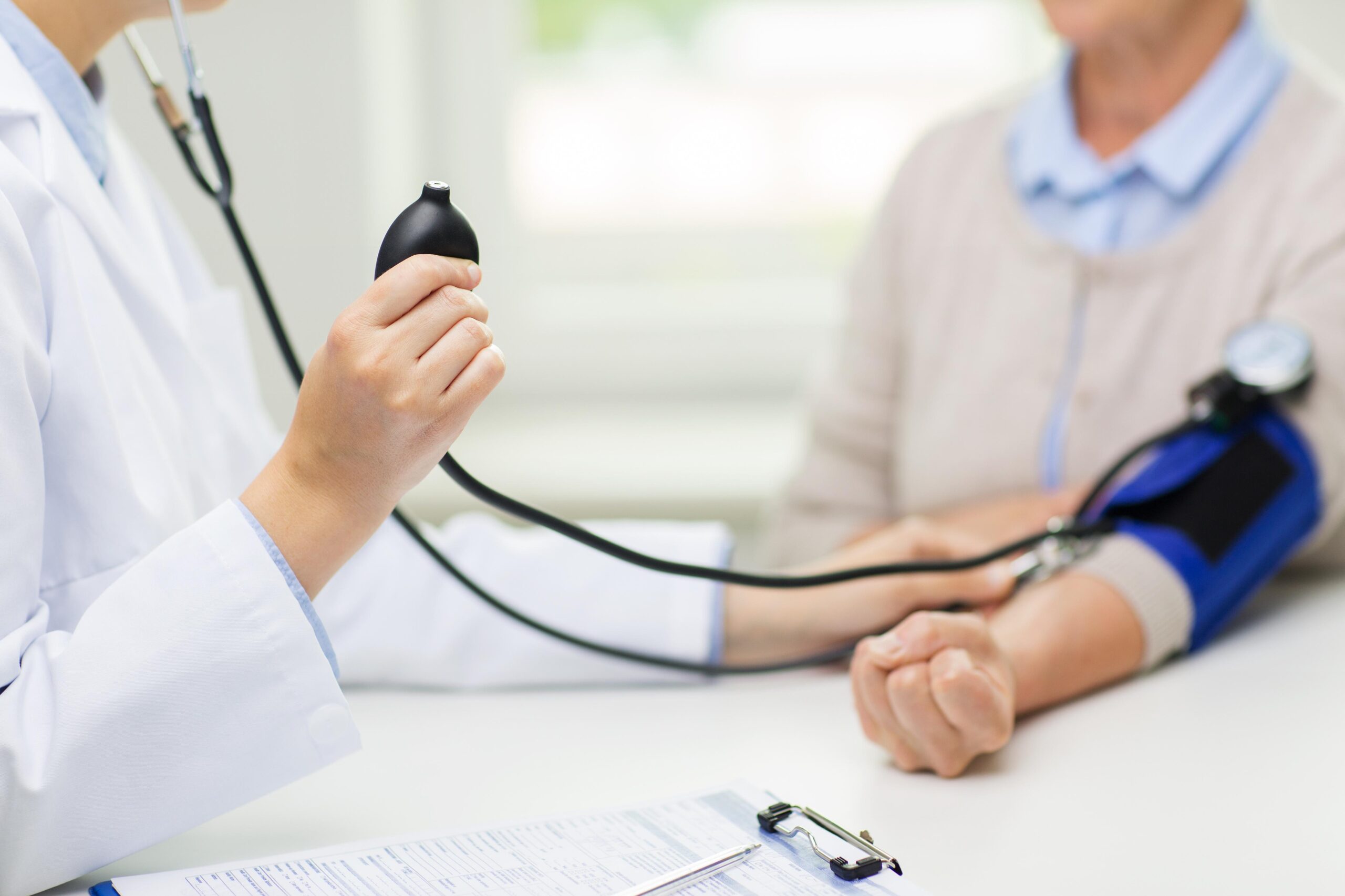 Doctor recording a patient's blood pressure, used to represent 5 essential health checks for 2025