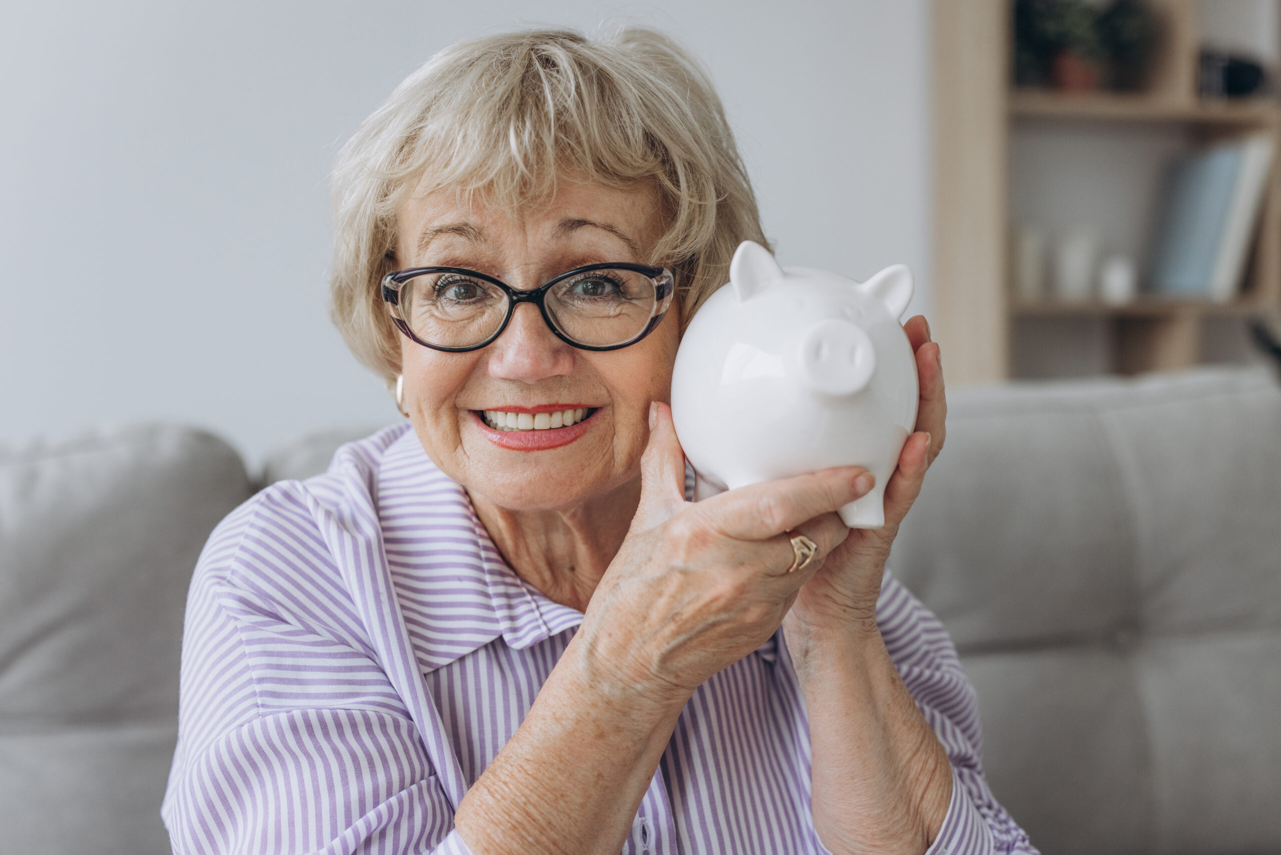 Mature lady holding a piggy bank as as source of private funding for home care