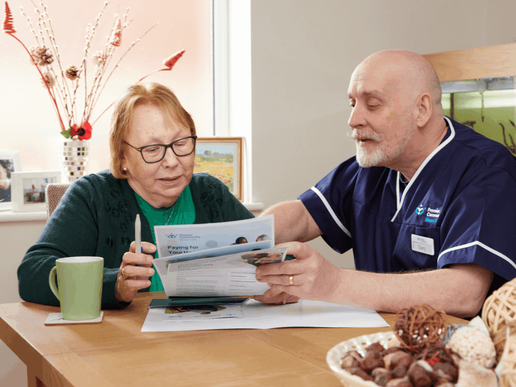 Premier Community Carer going through documents with a self-funding care service user