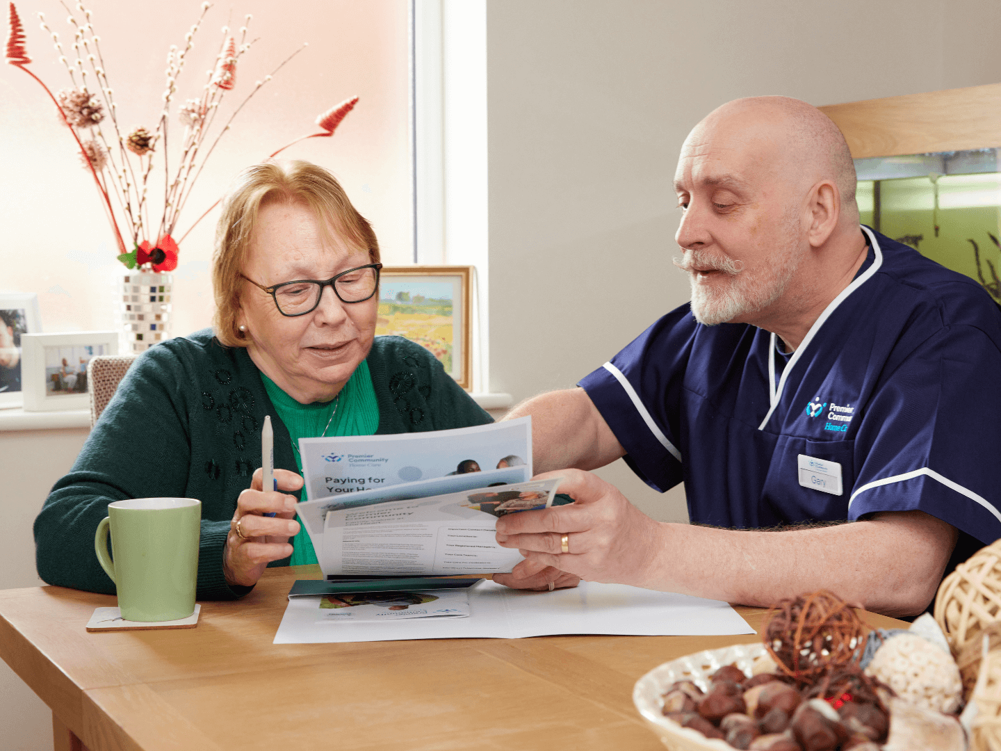 Premier Community Carer going through documents with a self-funding care service user