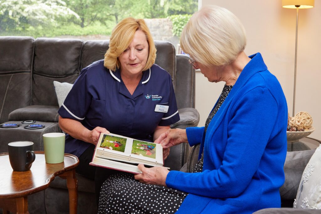 Premier Community Carer offering companionship care, looking through a photo album