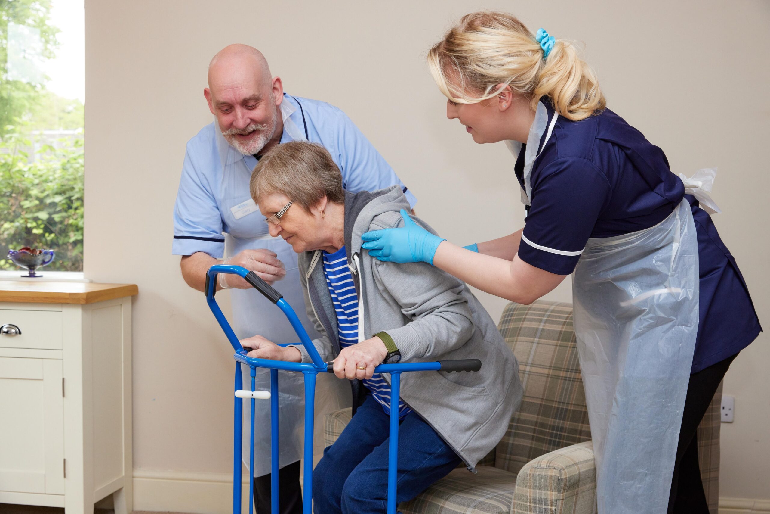Premier Community Carers using a routnda to help a service user out of her chair