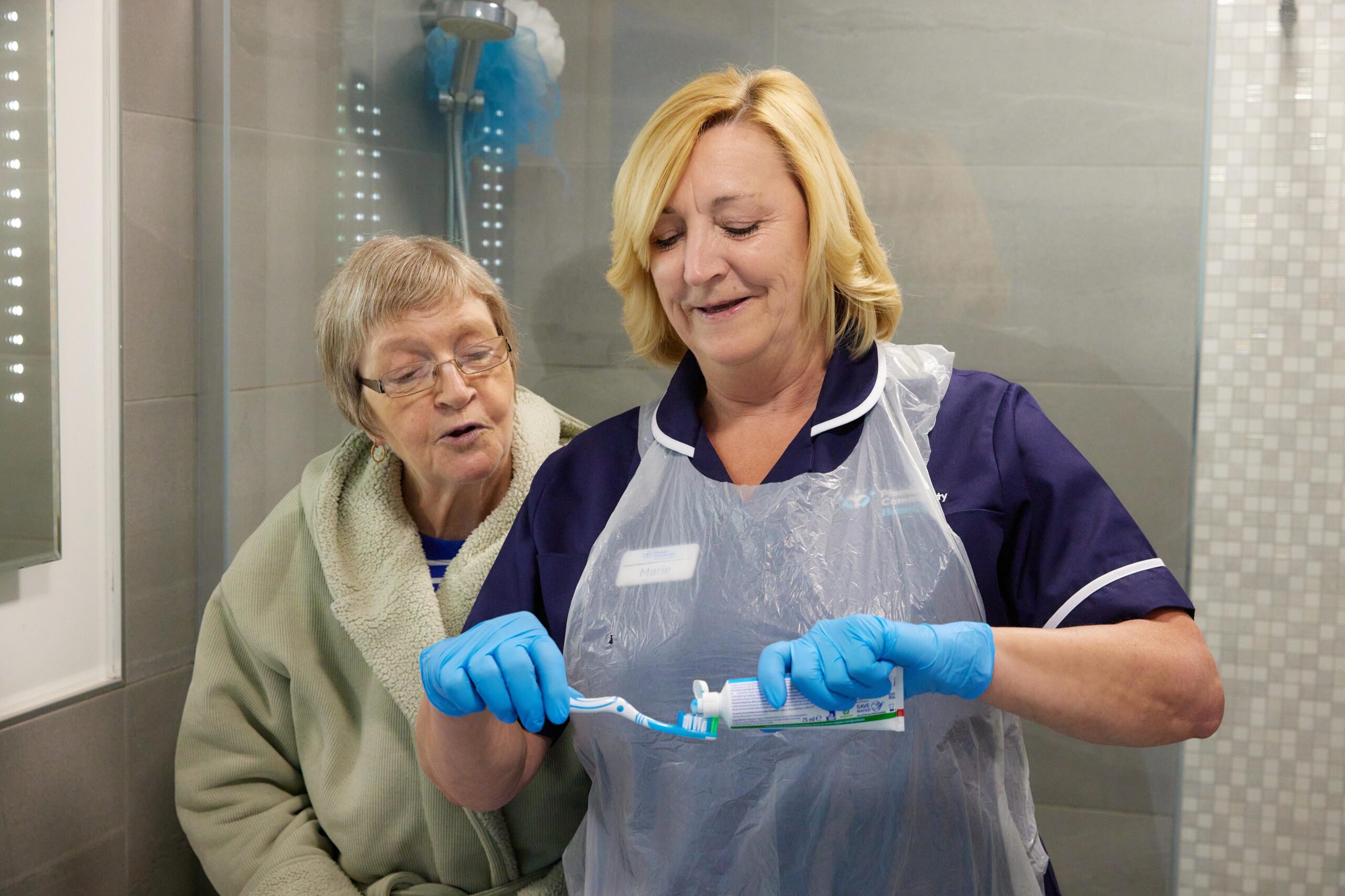 Premier Community carer applying toothpaste to a toothbrush for a client