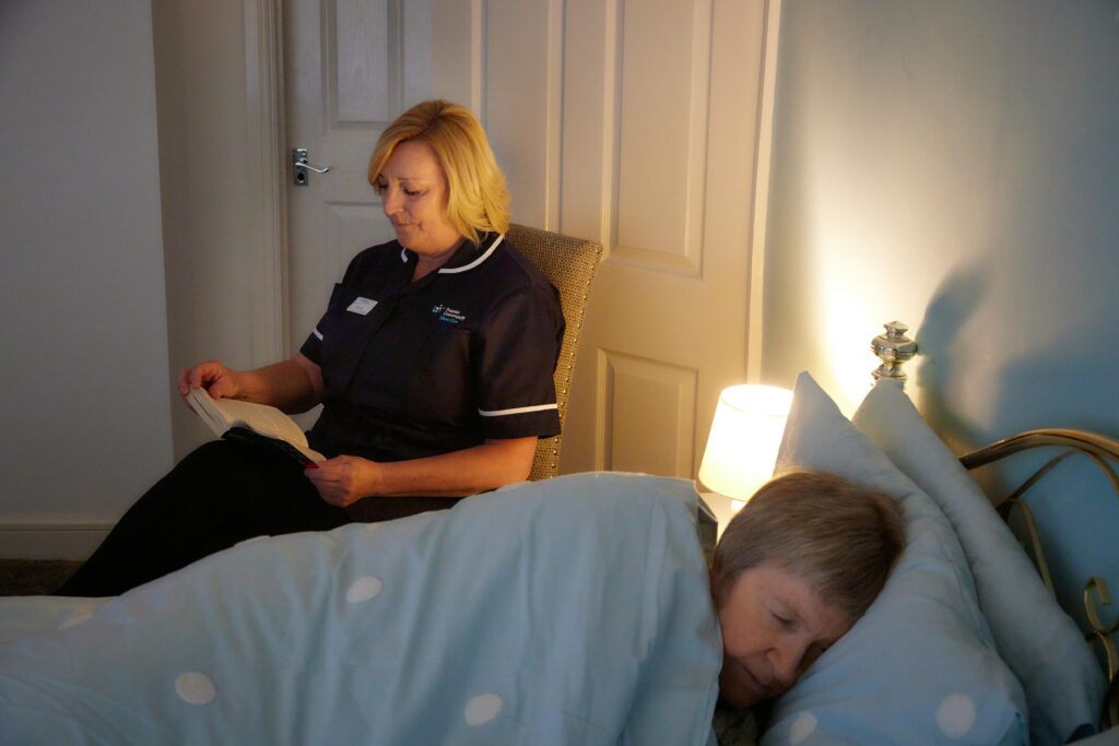 Premier Community Carer watches over a sleeping service user during Overnight Care