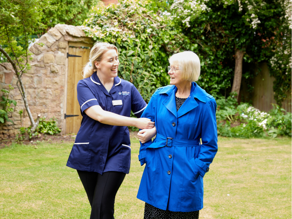 Carer and Service User walking cheerfully in the garden