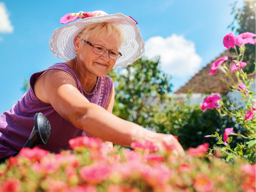 Elderly lady arranging her flowers on a summers day