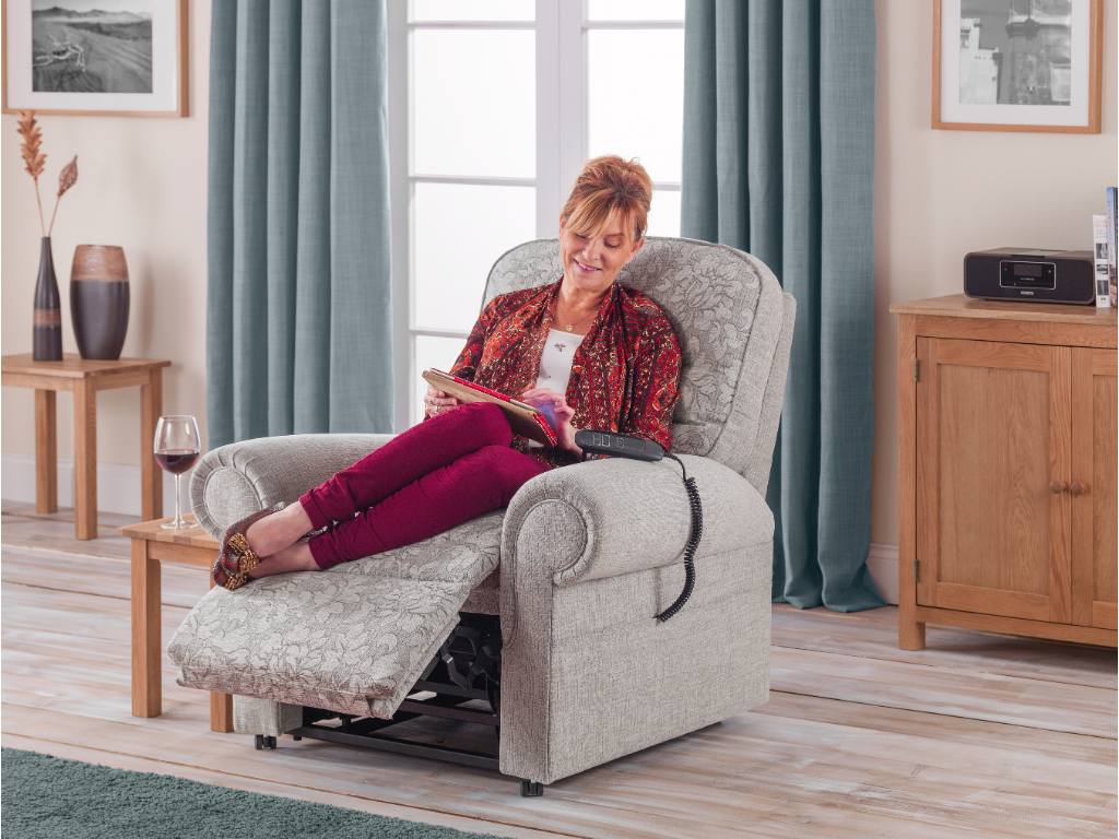 Lady sat on her riser recliner smiling at her ipad