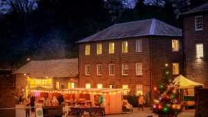 Image shows festive market lit up at Cromford Mills Derbyshire