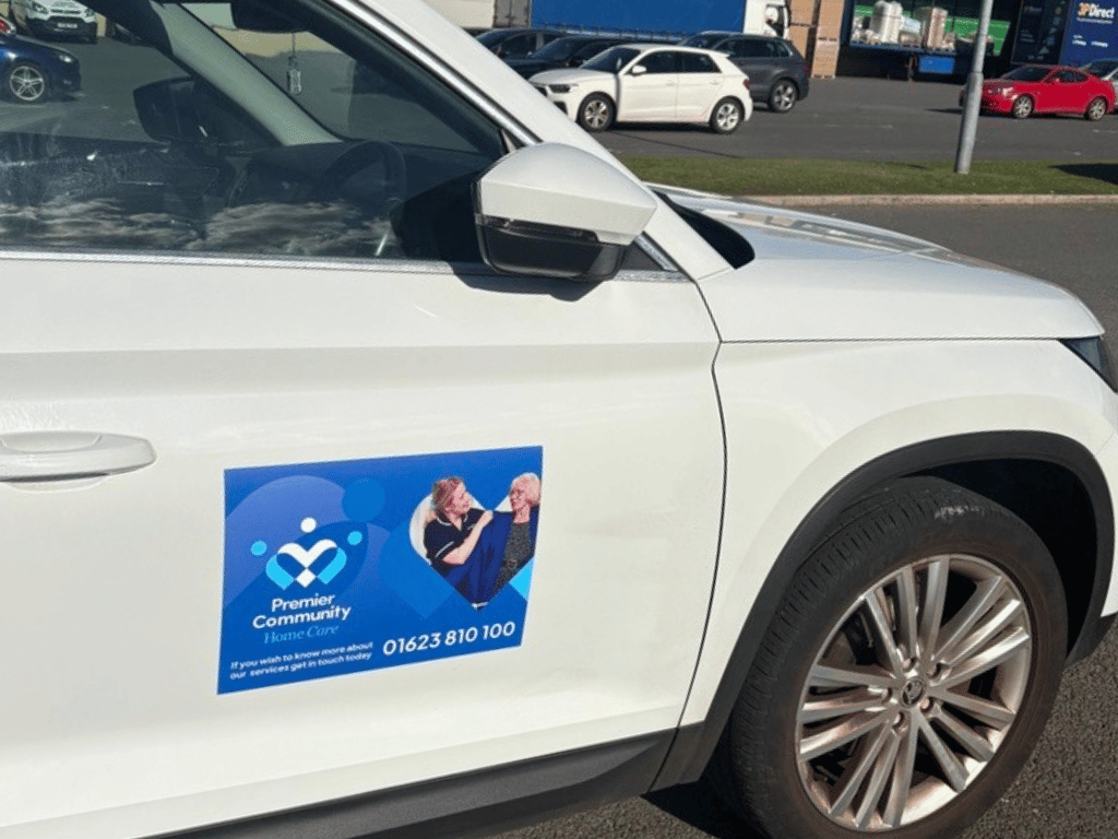 White car with blue Premier Community Home Care car magnet