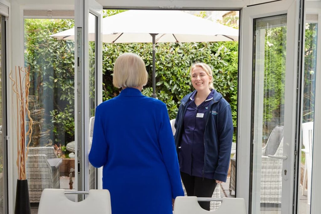 Young carer at the start of her career meeting a service user at their door