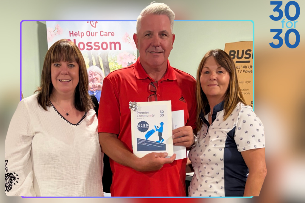 3 people stood together holding a donation image,