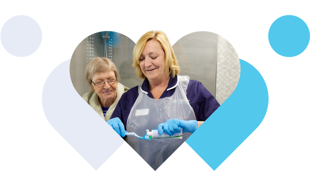 Home care worker helping an older woman brush her teeth at home