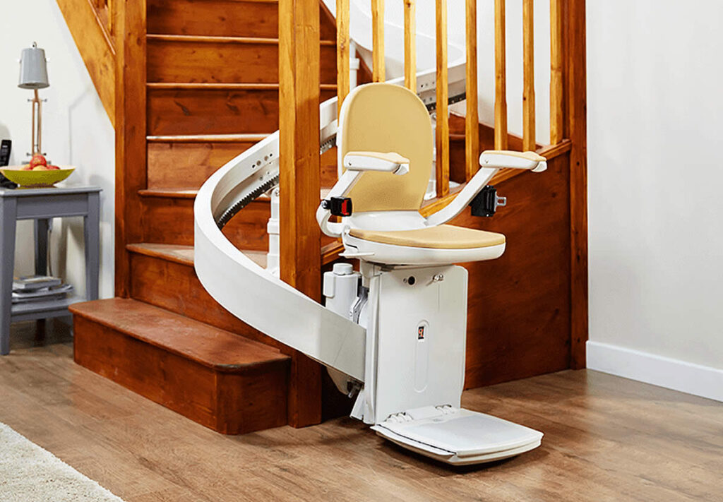 Stairlift positioned beside wooden stairs.